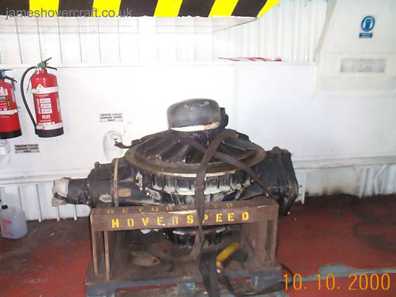 SRN4 systems tour - A gearbox being transported. Note its size compared to the two full-sized fire extinguishers. The input drive shaft to the gearbox would be connected to the left protrusion, the propeller shaft to the top (capped) and the lift fan to a protrusion on the bottom. An oil scavenge pump would be connected to the lowermost part of the flat plate on the right hand side, redistributing oil throughout the craft's systems.  (James Rowson).